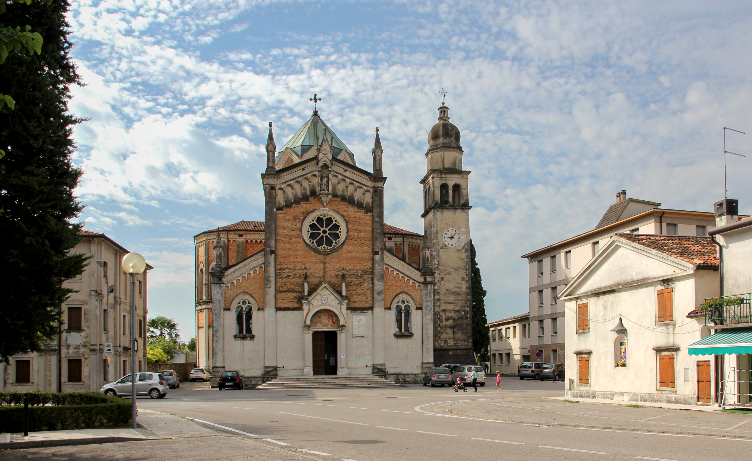 Backsteinkirche mit Zwiebelturm am leeren Platz – der Tag beginnt